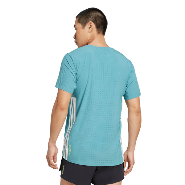 En person i Adidas Adizero Running T-Shirt, Herre, Powder Teal - fremstillet af 70 % genbrugsmaterialer - og sorte shorts står med ryggen til kameraet mod en almindelig baggrund.