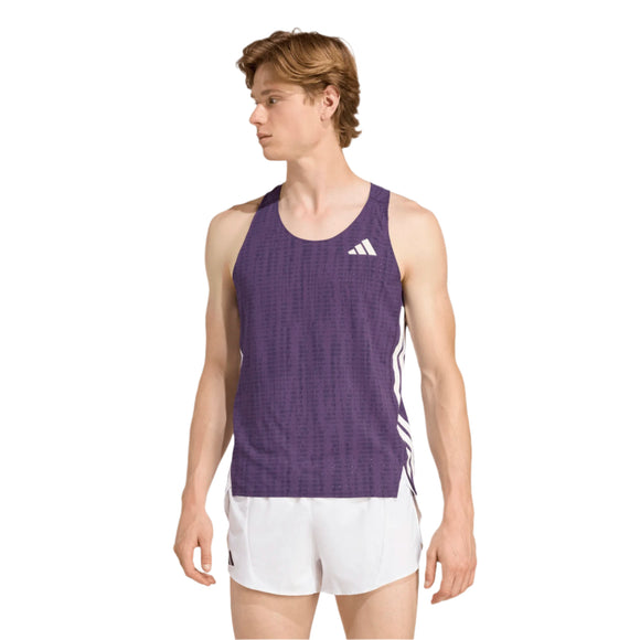 En mand står til venstre i en lilla Adidas Adizero Singlet (Aurplu/Nobink) til mænd, lavet af genbrugsmaterialer, parret med hvide løbeshorts mod en almindelig hvid baggrund.