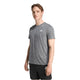 En mand står og kigger lidt til siden iført en Adidas Otr Mel Tee M til mænd i sort/grød og sorte shorts med hvide Adidas-logoer på en almindelig hvid baggrund.
