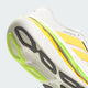 Nærbillede af Adidas Adistar BYD 2, Herre, CLOWHI/LUTA/SIGGNR, der viser en hvid sål med lysegule og neongrønne detaljer samt ordet DREAMSTRIKE trykt på mellemsålen.