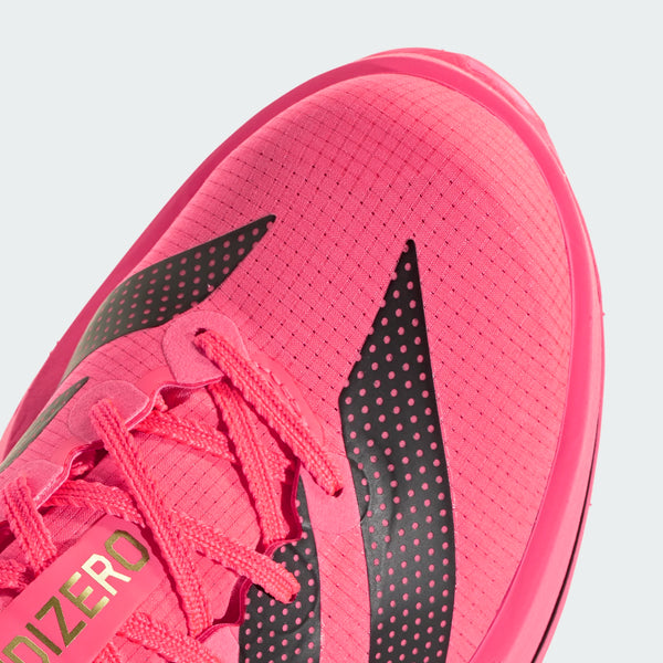 Nærbillede af tåområdet på Adidas Adizero Adios Pro 5, Dame, i farvekombinationen Soltur/Cblack/Lucred, med materiale i en levende lyserød farve og sorte, strukturerede striber, matchende lyserøde snørebånd samt »ADIZERO« trykt på en etiket tæt på snørebåndene. Denne iøjnefaldende sportssko, der er ideel som konkurrencesko til maratonløb, fremstår på en ensfarvet lysegrå baggrund.