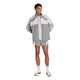 En person står foran en ensfarvet hvid baggrund iført stilfuldt herre-løbetøj: en lysegrå og hvid sportsjakke, Adidas Adizero Archive 5″ løbeshorts til mænd i farven Grethr/Greone, hvide Adidas-ankelstrømper og grå og hvide Adidas-løbesko – som fremhæver looket perfekt.