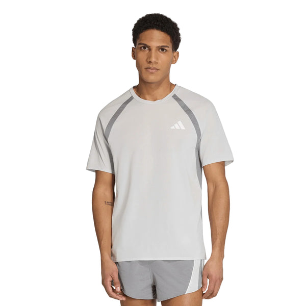 En mand står vendt fremad iført Adidas Adizero Archive løbetrøje til mænd i farven Greone/Grethr, med mørkegrå detaljer og et hvidt logo på venstre bryst. Designet er inspireret af adidas Adizero Archive-serien. Baggrunden er ensfarvet hvid.