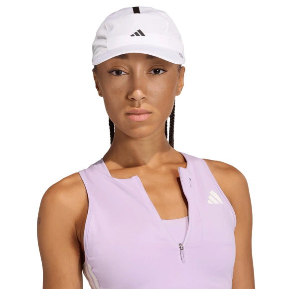 En person iført en hvid/sort Adidas Adizero Lightweight løbehue og en ærmeløs, lyselilla Adidas-trøje med lynlås foran, der står med ansigtet vendt fremad og et neutralt udtryk.
