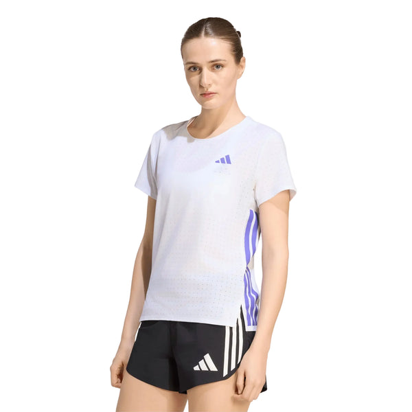 En kvinde står med ansigtet vendt fremad iført Adidas Adizero Running T-Shirt, Dame, i farvekombinationen hvid/Solpur samt sorte shorts. Den ensfarvede hvide baggrund fremhæver denne ultralette løbetrøje, der er perfekt til et sporty look.