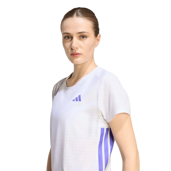 En brunhåret kvinde med håret sat op har en Adidas Adizero Running T-shirt, Dame, i farven White/Solpur på sig og står foran en ensfarvet hvid baggrund.