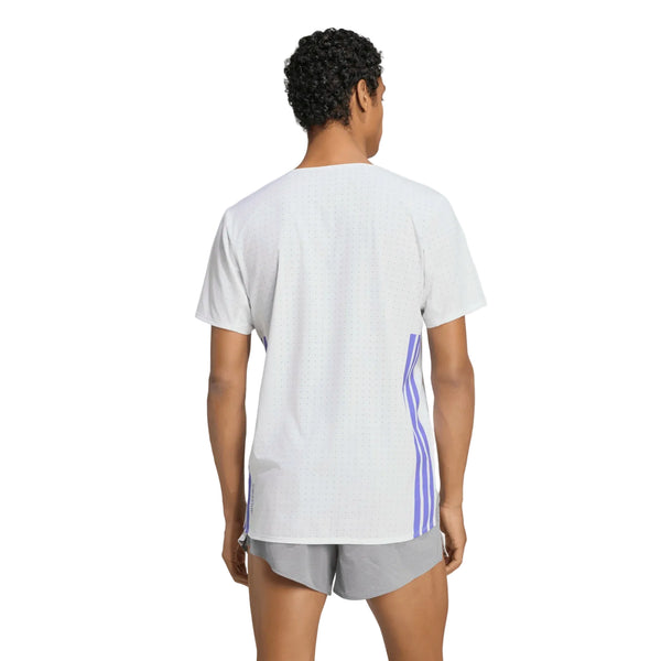 En person står med ryggen til kameraet iført en Adidas Adizero løbetrøje, Herre, hvid/solpur med lodrette blå striber på siderne og lysegrå shorts. T-shirten er fremstillet af genanvendte materialer. Baggrunden er ensfarvet hvid.