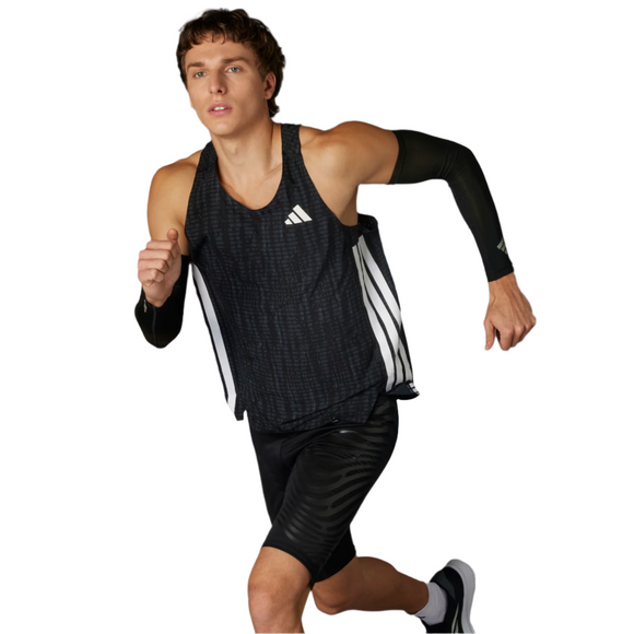 En mand i en Adidas Adizero Running Singlet, Herre, Carbon/Black, sorte kompressionsshorts og et sort armmanchet ses midt i et løb på en hvid baggrund.