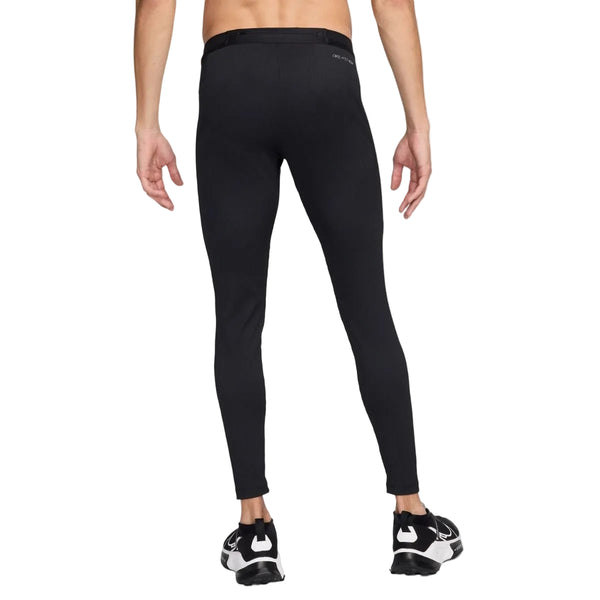 En person ses bagfra iført Nike AeroSwift ADV Running Tights, Herre, Black/Summit White, og sorte løbesko, stående mod en almindelig hvid baggrund.