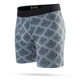 Stance Alhambra Wholester, Herre, Blå er et par lyseblå boxershorts til mænd med et gentagende geometrisk mønster i mørkegrå og gul. De er fremstillet af det luksuriøse Butter Blend-materiale, der sikrer optimal komfort, og er afsluttet med en sort linning med mærkelogo. Produktet vises på en ensfarvet hvid baggrund.