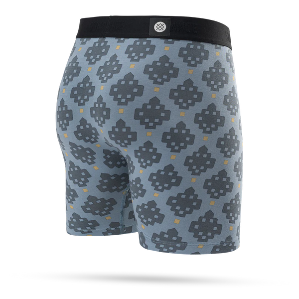 Stance Alhambra Wholester, Herre, Blue boxershorts er designet med fokus på komfort og har en tætsiddende pasform med blå baggrund og et geometrisk mønster over hele overfladen i mørkegrå og gul. De er designet med en sort linning, der er prydet med et lille cirkulært logo i midten, hvilket gør disse boxershorts til et uundværligt stykke herreundertøj fra Stance.