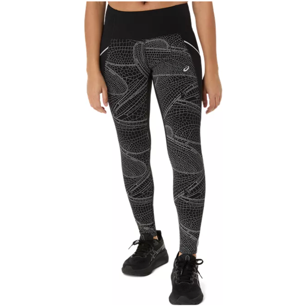 En kvinde iført Asics Limited Series Lite-Show Tight, Dame leggings i Performance Black med et hvidt geometrisk print, sorte sko og en sort linning, står på en almindelig hvid baggrund.