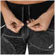 En person justerer snoren på Asics Limited Series Lite-Show Tight, Dame, Performance Black leggings med et hvidt, prikket geometrisk mønster og ASICS-logoet nær hoften. Snorene viser SOUND MIND SOUND BODY.