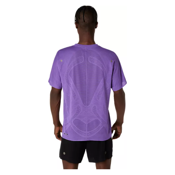 En person står med ryggen til kameraet iført en Asics Metarun Ss Top til herre i farven Edo Purple. T-shirten har mønster på ryggen, små ventilationshuller ved skuldrene og er lavet i svedtransporterende materiale for ekstra komfort under træning.
