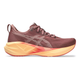 Asics Novablast 5 Dame i Rubble Red/Fawn er en rødbrun løbesko med maksimal støddæmpning, en gul-orange gradient tyk sål, mesh-overdel og subtilt ASICS-logomønster. Vist fra siden på en hvid baggrund.