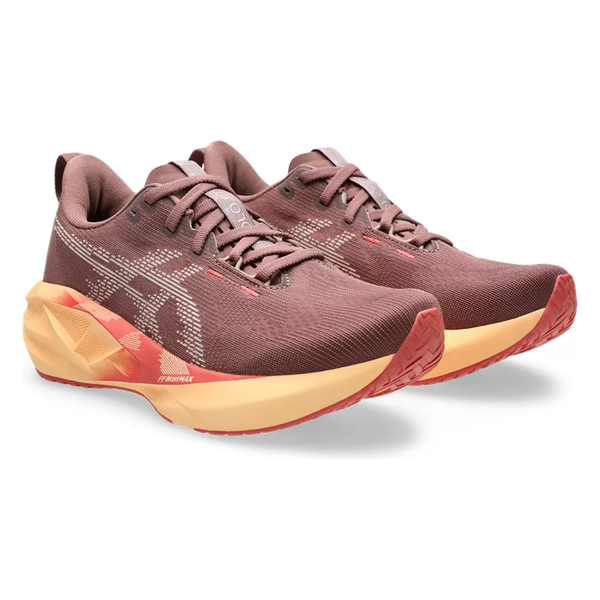 Et par Asics Novablast 5 Dame løbesko i Rubble Red/Fawn med beige såler og orange detaljer, overdel i mesh, snørebånd, maksimal affjedring og et stiliseret logo på siderne. Placeret side om side i en lille vinkel.