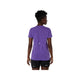 En person står med front mod kameraet iført Asics Road Seamless SS Top, Dame, Edo Purple og sorte shorts, der viser åndbart træningstøj mod en almindelig hvid baggrund.