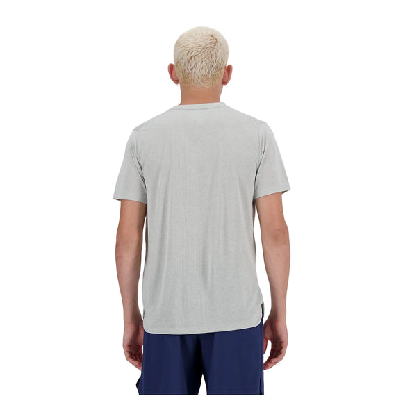 En person med kort, lysblondt hår ses bagfra iført en grå New Balance Athletics T-shirt, Herre og mørkeblå shorts, stående mod en almindelig hvid baggrund.