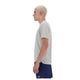En person med kort, afbleget blondt hår ses i profil iført en grå New Balance Athletics T-shirt (Herre) på en hvid baggrund.