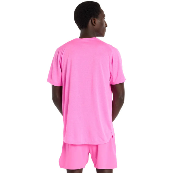 En person med kort hår står og kigger væk fra kameraet iført en New Balance Athletics T-Shirt, Herre, Pink Heat Heather og matchende lyserøde shorts på en almindelig hvid baggrund.