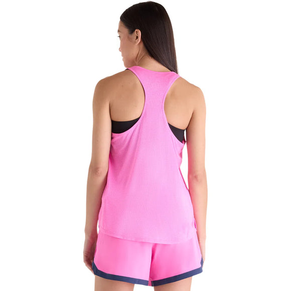 En kvinde med glat, brunt hår bærer en pink New Balance Athletics Tank til kvinder i Pink Heat Heather/Slate Grey med NB Ice X-teknologi sammen med pink sportsshorts med mørk linning og kant.