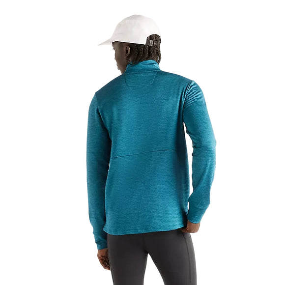 En person set bagfra, iført en blågrøn New Balance Athletics Heat Grid 1/2 Zip, Herre, Streamsong-trøje og en hvid kasket.