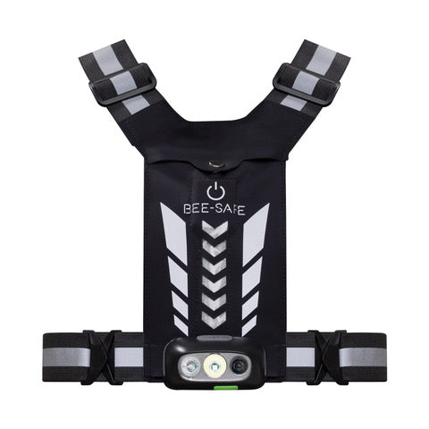 BeeSafe Led Harness USB Phone Pocket Glow er en unisex, sølvfarvet sikkerhedsvest med gråt chevronmønster, LED-lys med tænd/sluk-knap foran, justerbare stropper med refleksbånd og en telefonlomme.