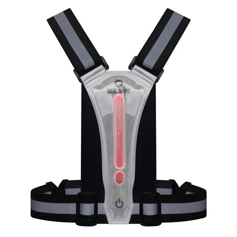BeeSafe Led Harness USB Phone Pocket Glow, Unisex, Silver har justerbare sorte stropper, et centralt klart panel med en lodret rød LED, tænd/sluk-knap, mulighed for genopladning via USB, øget synlighed og BeeSafe-branding øverst.