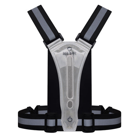 BeeSafe Led Harness USB Phone Pocket Glow, Unisex i sølv, har justerbare stropper, en telefonlomme, en central oplyst tænd/sluk-knap med "Bee Safe" i toppen og er genopladelig via USB.