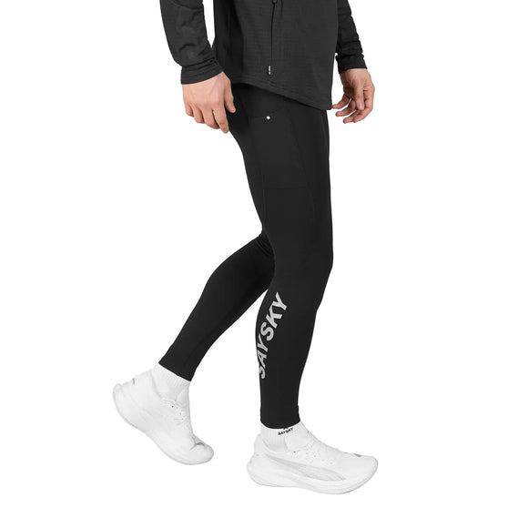 En person iført sorte Blaze+ Long Winter Tights, Herre, Black med et logo på underbenet og hvide sneakers.