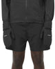 En person iført sorte løbeshorts og en langærmet jakke med Salomon Bonatti Pro WP Mitten, Unisex, Deep Black trukket ned over hænderne.