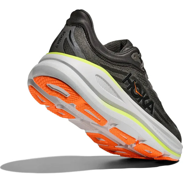 A Hoka Bondi 9 Herre løbesko i Asphalt Grey/Gravel set bagfra, med en tyk hvid og grå sål samt orange og gule detaljer for ekstra komfort, og Hoka-logoet synligt på siden.
