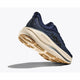 A Hoka Bondi 9 herre løbesko i Midnight Blue/Varsity Navy vises fra en vinkel, der fremhæver den tykke, beige sål for maksimal komfort og greb. HOKA-logoet er tydeligt på siden.