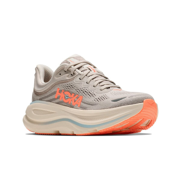Hoka Bondi 9 Dame i farven River Rock Grey / Mineral Ore har en tyk, buet sål, detaljer i koralorange og mærkelogo på siden. Den beige og koralorange ydersål i gummi sikrer løbere maksimal komfort og støtte.