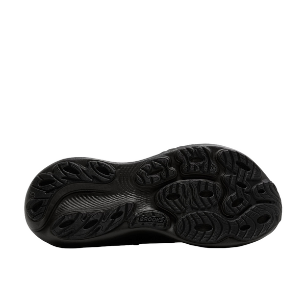 Billedet viser den sorte, strukturerede sål på Brooks Adrenaline GTS 25, Dame, Black/Black/Ebony skoen nedefra, med flere riller og cirkulære slidbanemønstre for stabilitet, greb og støtte.