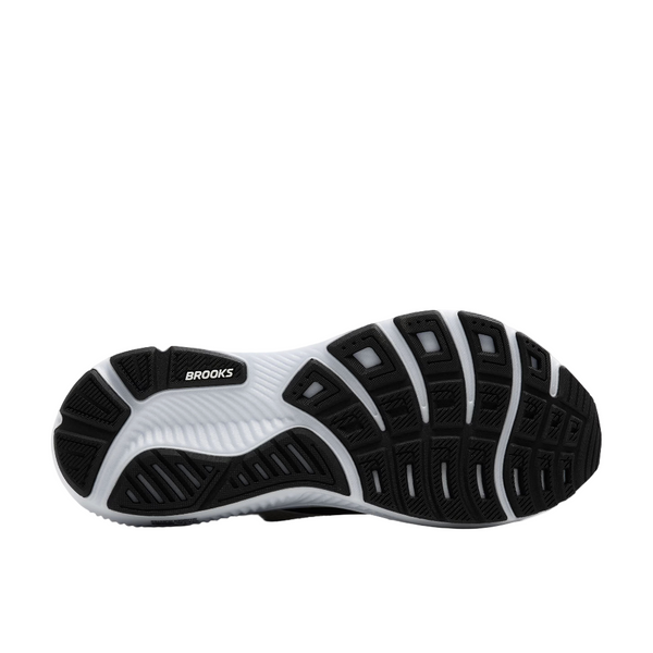 Billedet viser den sort/grå/hvide gummiydersål på Brooks Ghost 17 Dame. Den har segmenterede grebsmønstre for blød dæmpning, og Brooks-logoet er synligt nær midten.