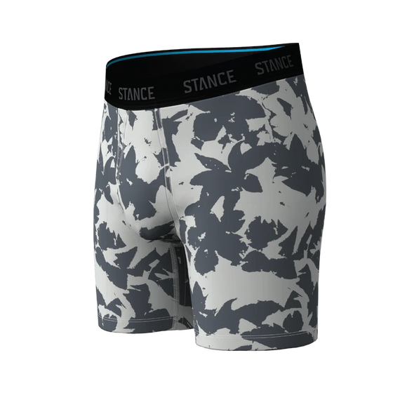Et par Stance Brush Stroke Wholester-boxershorts til mænd i gråt, med en sort linning med påskriften STANCE, et blåt inderfor på linningen og et abstrakt mønster i gråt og hvidt på det bløde Butter Blend™-stof. Boxershortsene er afbilledet på en ensfarvet baggrund.