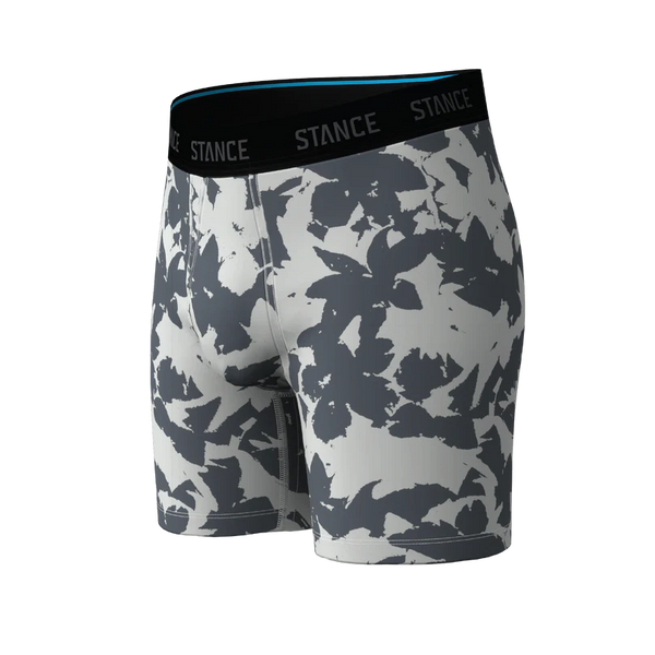 Et par Stance Brush Stroke Wholester-boxershorts til mænd i gråt, med en sort linning med påskriften STANCE, et blåt inderfor på linningen og et abstrakt mønster i gråt og hvidt på det bløde Butter Blend™-stof. Boxershortsene er afbilledet på en ensfarvet baggrund.