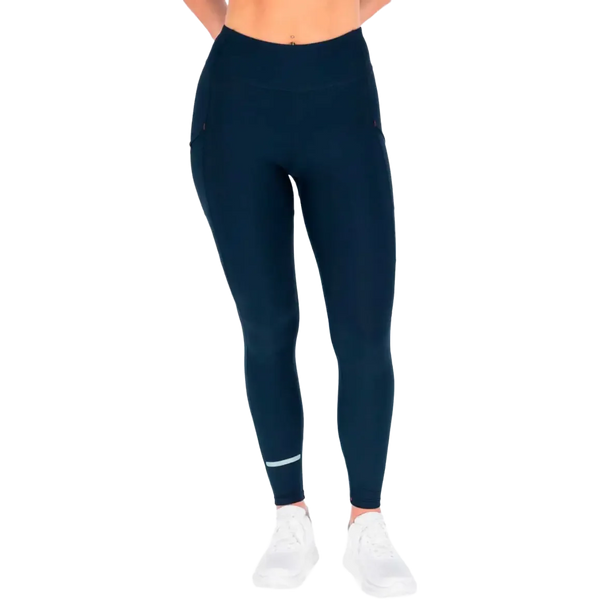 En person har Fusion C3+ Long Training Tight, Dame, i farven Night Blue på sammen med hvide sportssko. Billedet er beskåret fra skuldrene til fødderne, så overkroppen og hovedet ikke er med. Baggrunden er ensfarvet og lys, hvilket fremhæver den elegante, moderne stil i damernes sportstøj.