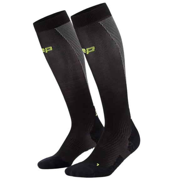 Et par CEP Core Run Ultralight Compression Socks til mænd i sort/grå med gulgrønt branding i toppen på en hvid baggrund.