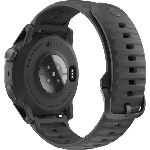 Billedet viser bagsiden af et sort COROS Apex 4 Multisport Watch med en rund kasse, silikonerem, opladningsport og sensorkomponenter på undersiden.