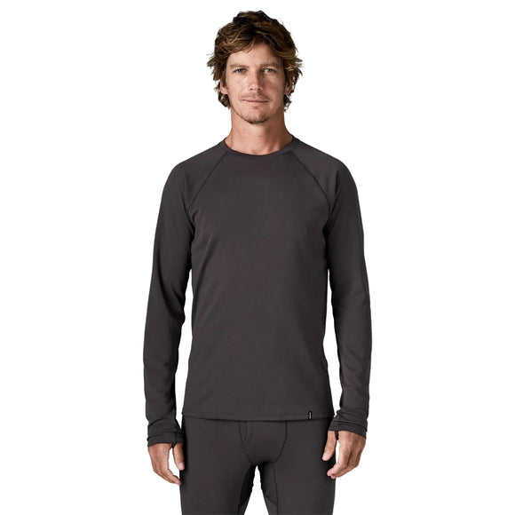 En mand iført en Patagonia Cap MW Crew, Herre, Ink Black og matchende undertrøje til løb i koldt vejr.