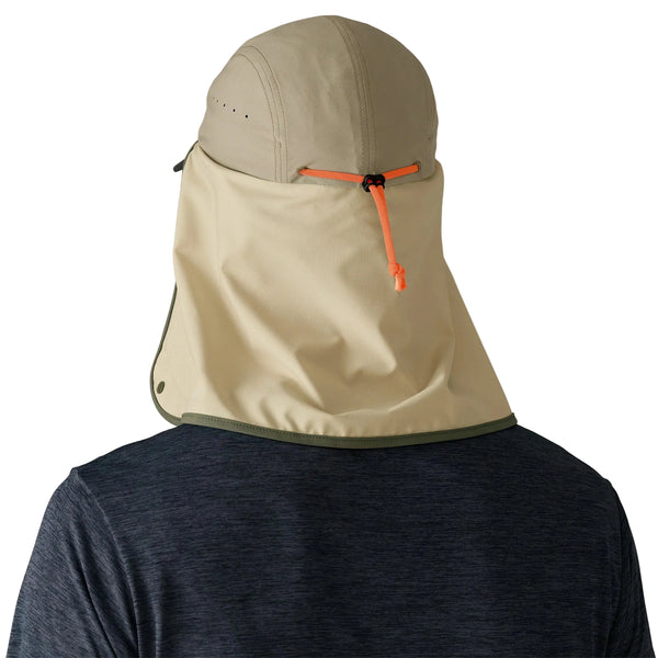 En person set bagfra bærer en Patagonia Caped Merganzer Hat, Unisex, i River Rock Green, med nakkeklap og orange justerbar strop, sammen med en mørkeblå skjorte.