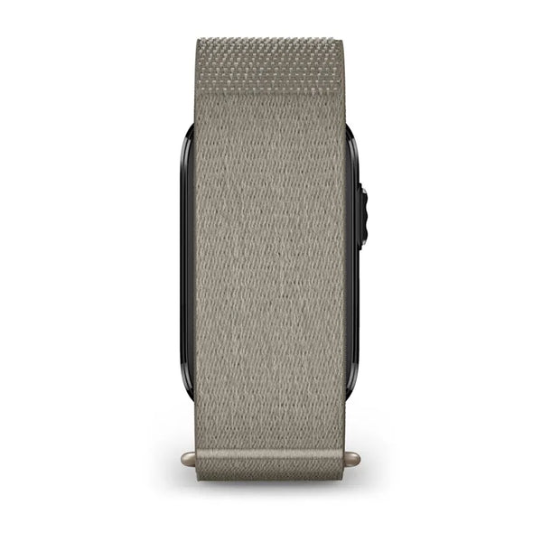 Et elegant Garmin Cirqa Smart Band i farven French Grey, med en vævet nylonrem, der dækker en stor del af urskiven, vises her set både fra siden og forfra, med en sort betjeningsknap, der kan ses på højre kant. Dette aktivitetsarmbånd tilbyder omfattende funktioner til daglig tracking, såsom søvnregistrering.