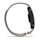 Set fra siden: Garmin Cirqa Smart Band i farven »French Grey« med en elegant sort skærm og et slankt, struktureret armbånd med en kant med løkkeformet design og lås. Denne enhed, der også kaldes et »aktivitetsarmbånd«, forener stil og funktionalitet med funktioner som søvnregistrering. Garmin-logoet ses på siden af smarturet.