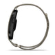 Et Garmin Cirqa Smart Band i farven »French Grey« ses her set fra siden, hvor dets slanke, sorte, rektangulære urhus og det lysegrå, perforerede rem med magnetlås kommer til sin ret. Dette stilfulde aktivitetsarmbånd er designet til at være behageligt at have på hele dagen og byder på avancerede funktioner såsom søvnregistrering.