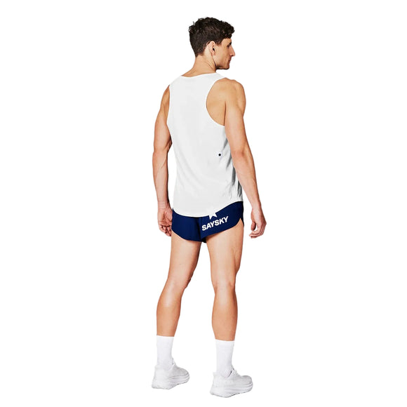 En mand iført Saysky Clean Combat Pro Singlet, Herre, White står med ryggen til kameraet på en almindelig hvid baggrund - et ultralet, åndbart og hurtigtørrende valg til træning. Han har også marineblå shorts, hvide sokker og sko på.