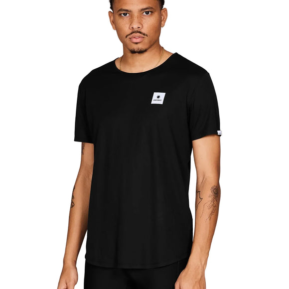En mand med kort hår, trimmet skæg og tatoverede arme ser frem for sig iført Saysky Clean Combat Pro T-Shirt til mænd i sort med et lille firkantet hvidt brystmærke og et ærmemærke.