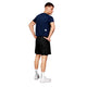 En mand står med ryggen til og er iført Saysky Clean Combat Pro T-Shirt, Herre, Blue, sorte shorts, hvide sokker og sportssko. Denne åndbar t-shirt herre er udstillet mod en almindelig hvid baggrund.