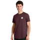 En mand står foran en ensfarvet hvid baggrund og ser ind i kameraet med et neutralt udtryk, iført Saysky Clean Combat Pro T-shirt, Herre i farven Burgundy – en kortærmet funktions-T-shirt med et lille hvidt, rektangulært logo på brystet. Denne hurtigtørrende T-shirt sikrer komfort og ydeevne til enhver lejlighed.